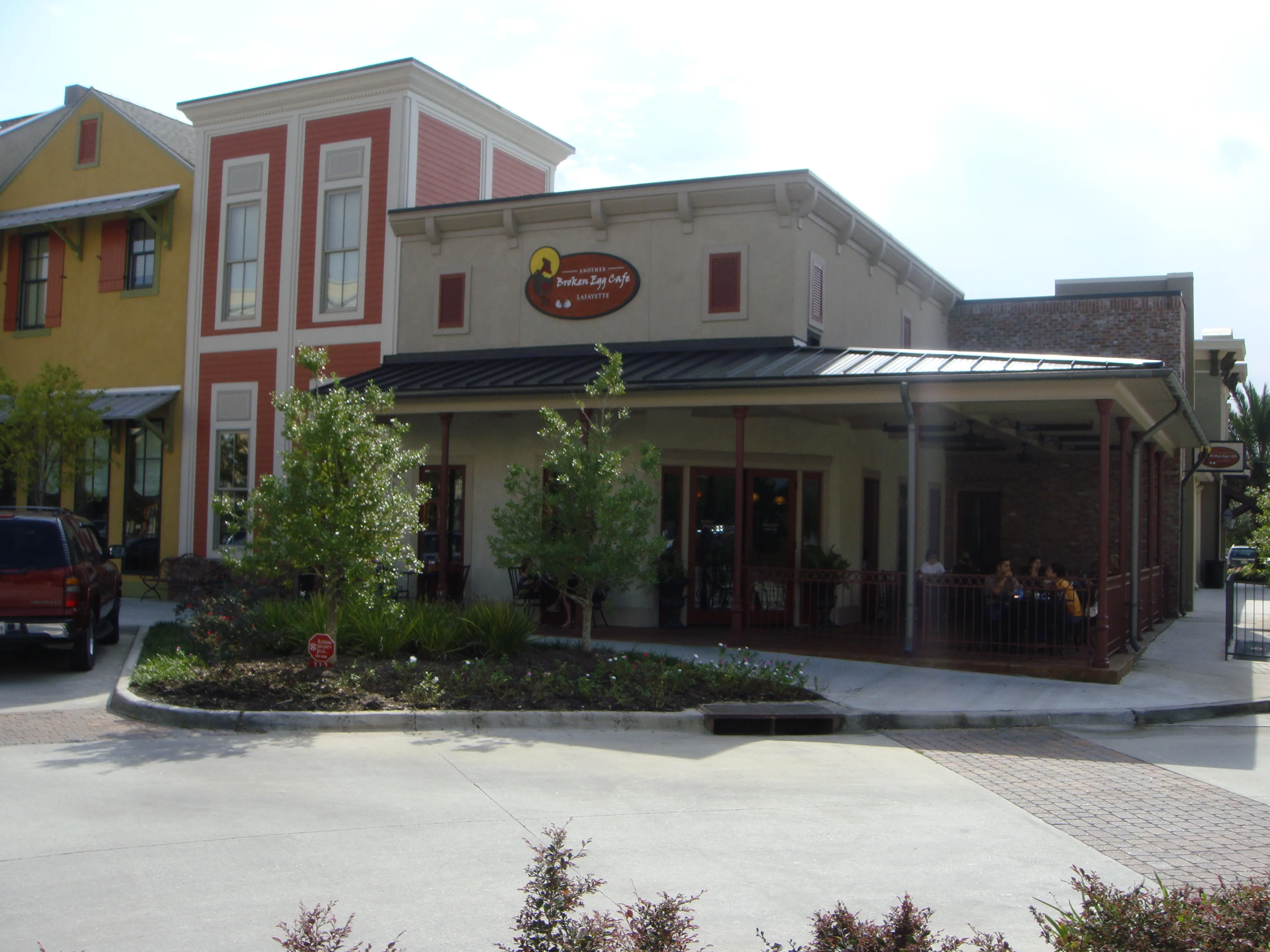 Another Broken Egg Cafe in Lafayette — stucco storefront with a covered patio and red-trimmed upper façade.