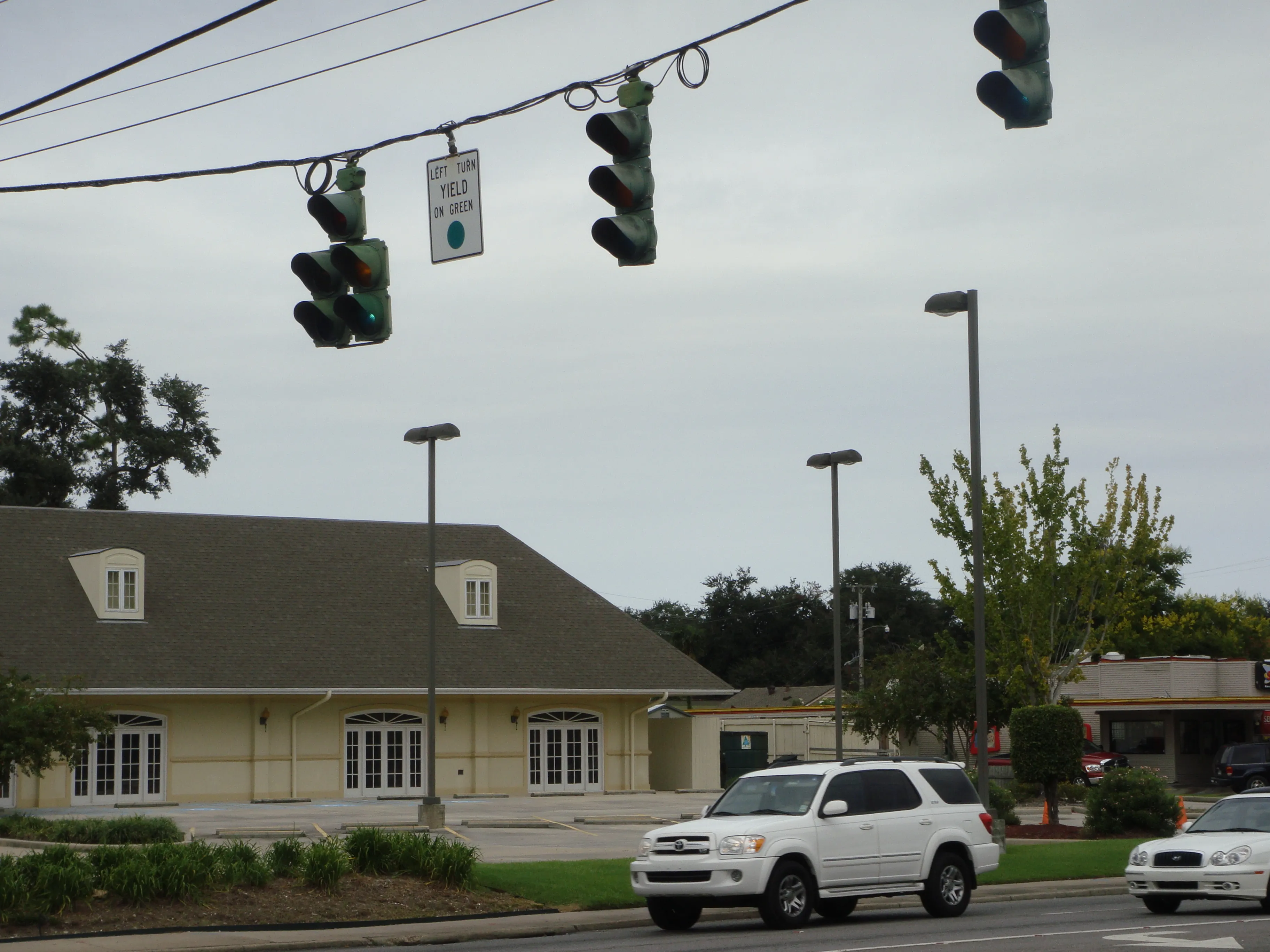 Street view of the Ruth's Chris Steak House, a low cream-colored building with arched French doors.